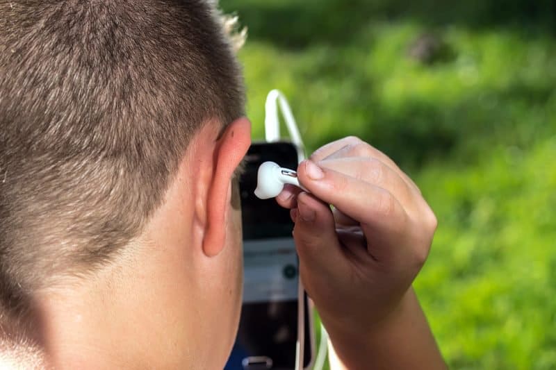 musicinan inserting an earplug