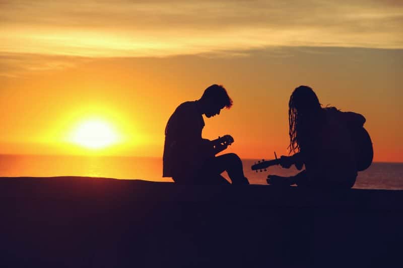 two musicians playing guitar outside