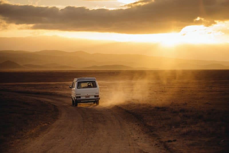 single van driving in a desert, symbolizing a solo artist on their own