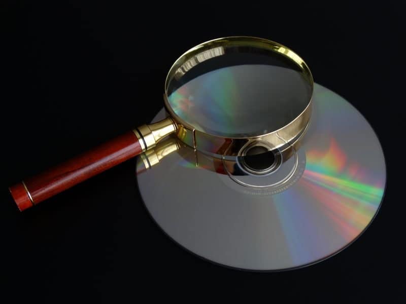 magnifying glass held up to a compact disc