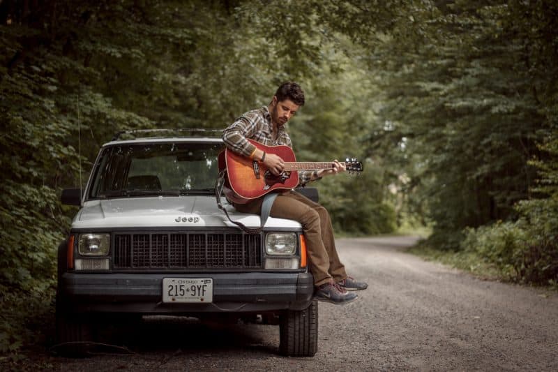 person playing an acoustic guitar outside