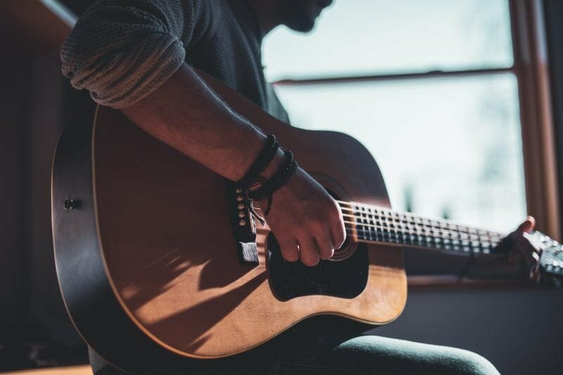 person playing acoustic guitar