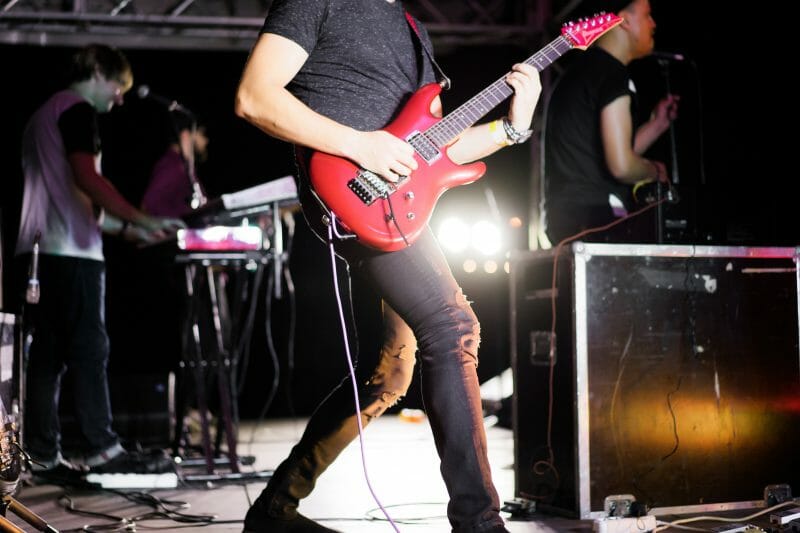 person playing electric guitar on stage