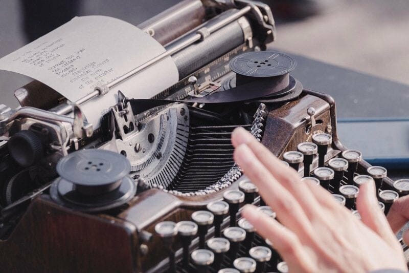 a person typing lyrics on a typewriter