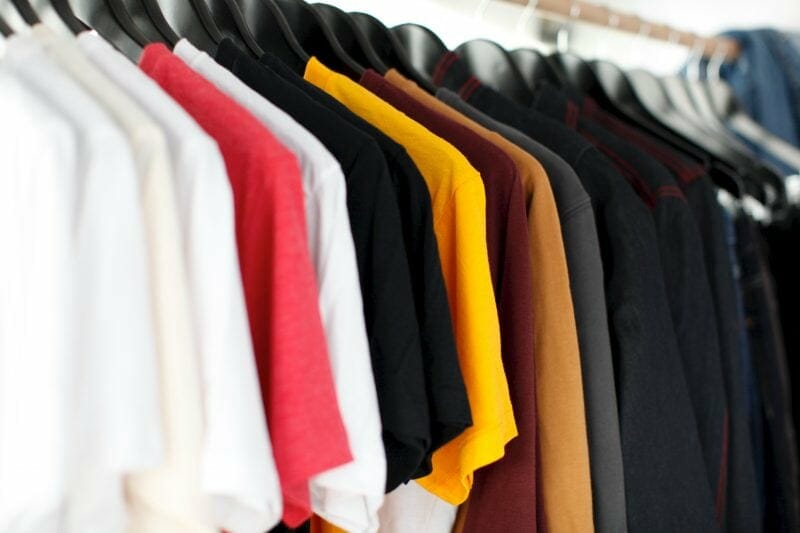 a rack of shirts at an artist's merchandise table