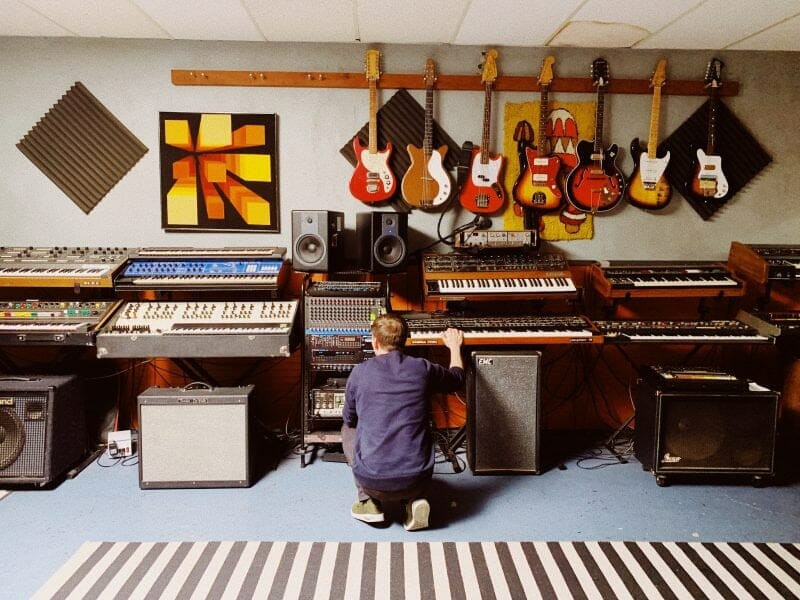 room full of guitars, keyboards, and mixing gear 