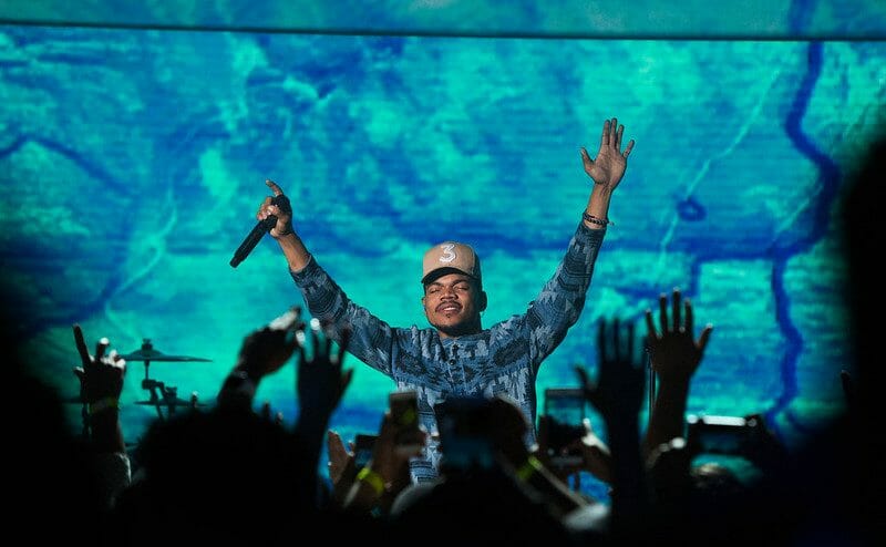 chance the rapper performing on stage wearing his iconic 3 hat