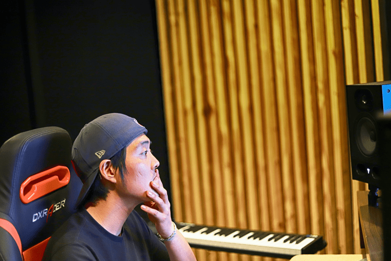 musician sitting in a studio next to a keyboard