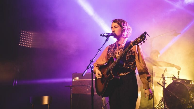 artist singing and playing guitar