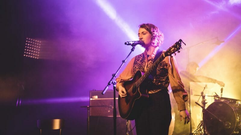 artist singing and playing guitar