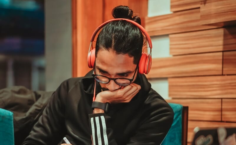 man listening to music intently with red headphones