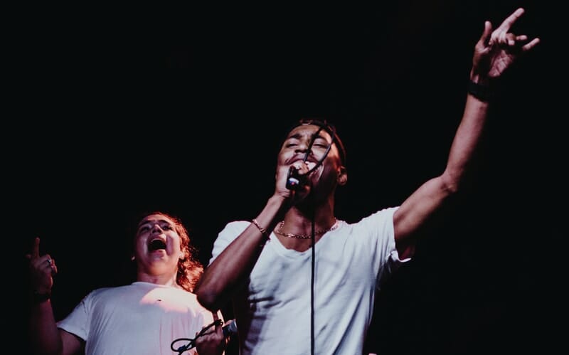 person singing into a microphone on stage