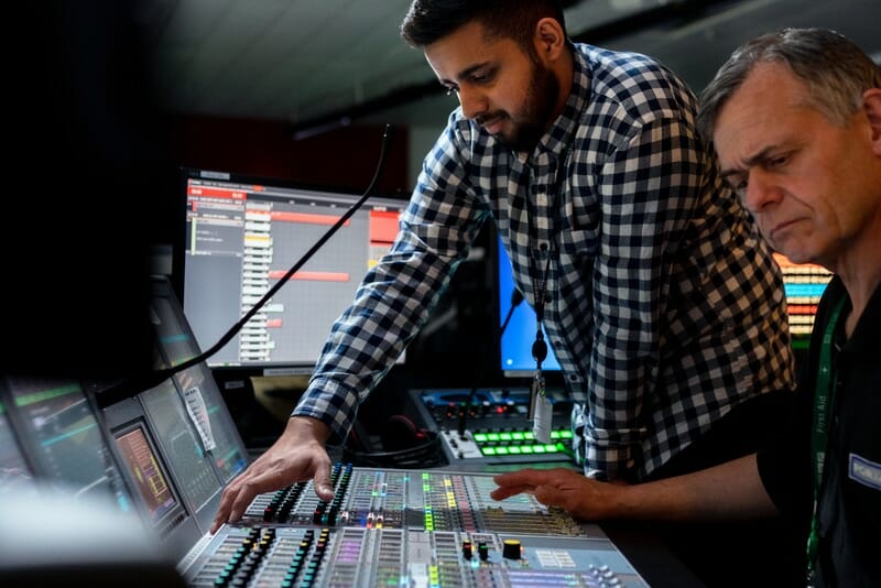 audio engineers working at a mixing desk