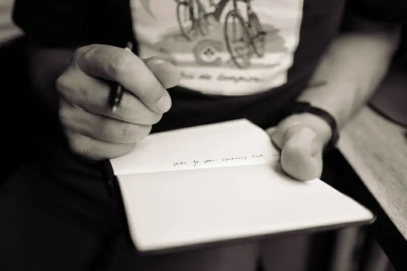 person writing lyrics in a notepad